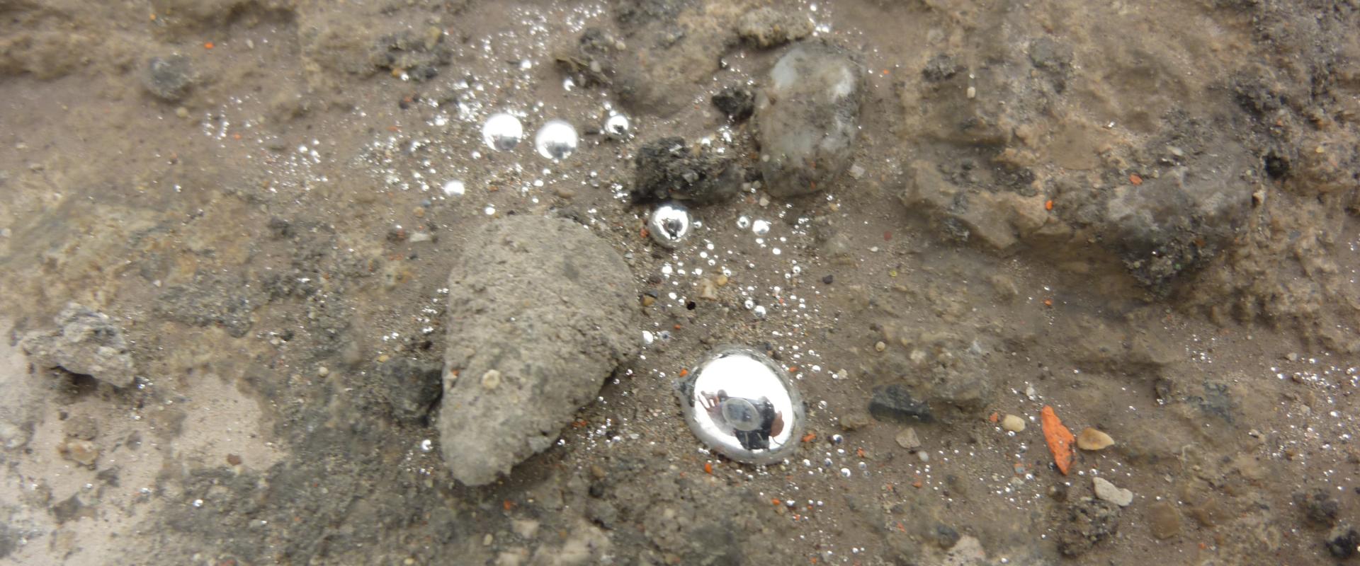 Gouttelettes de mercure libre sur une dalle de béton