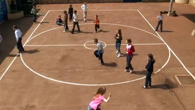 Terrain de sport en terre battue dans une cour d'école.